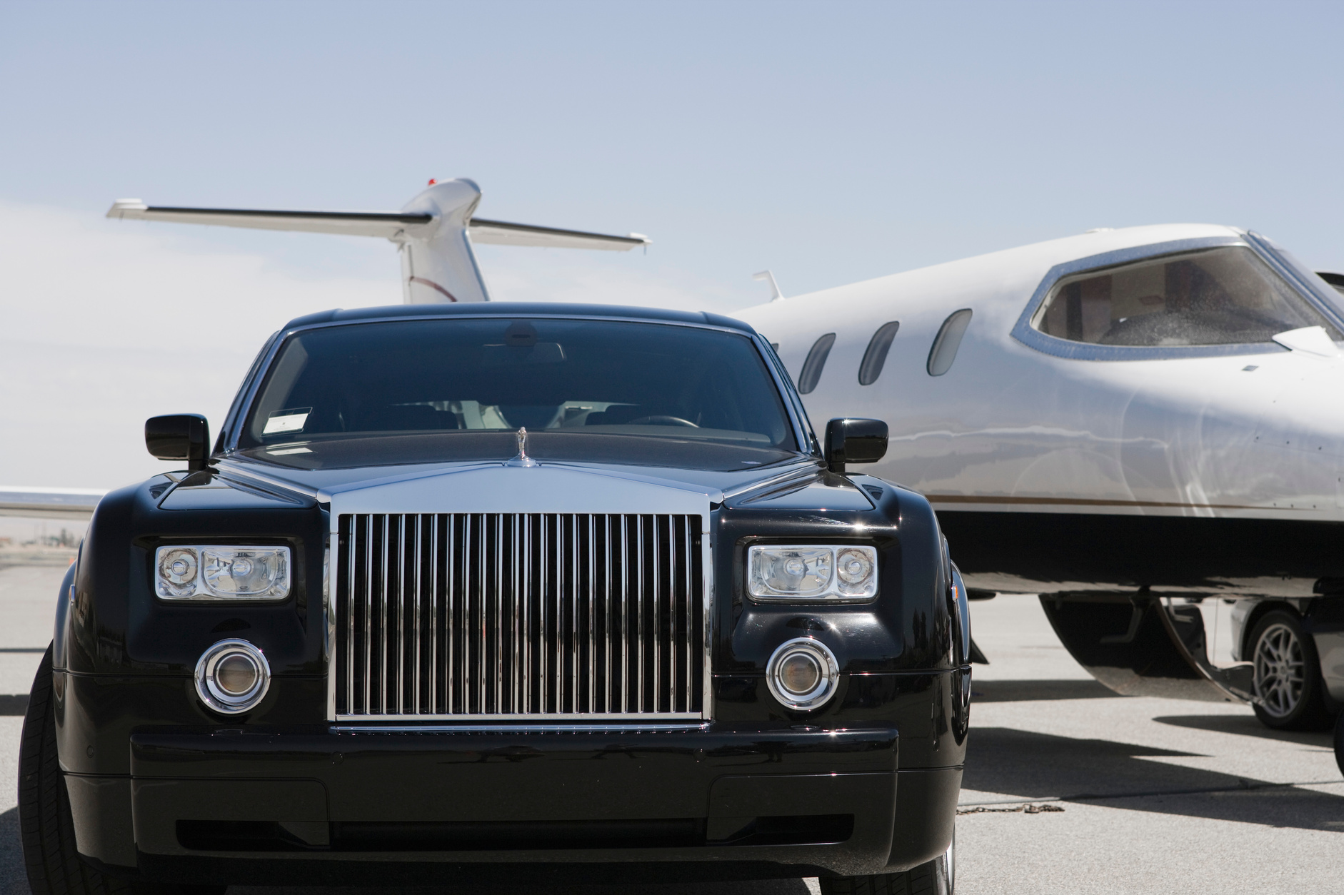 limousine and private jet on landing strip.